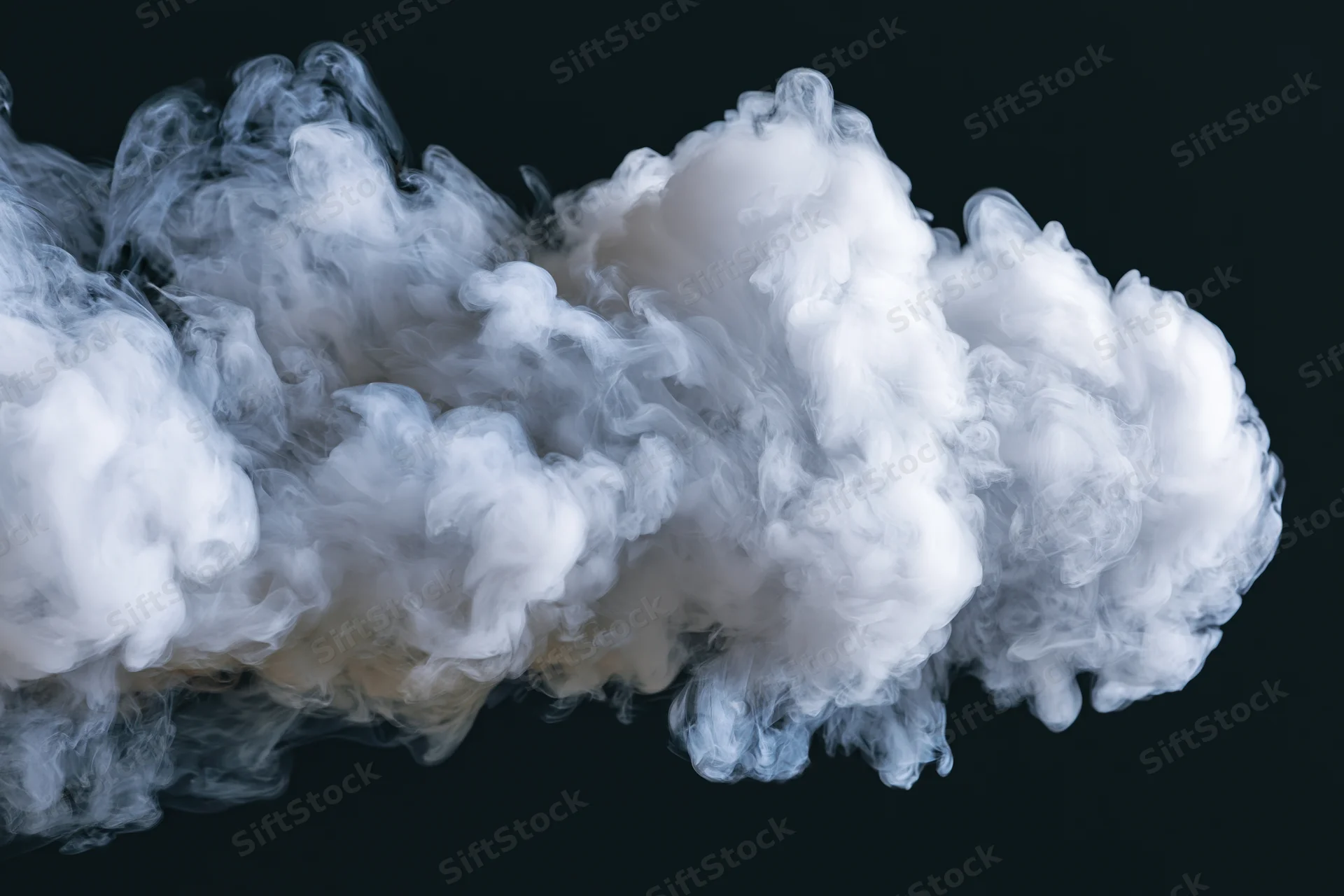 White smoke cloud drifting and dispersing midair against black background