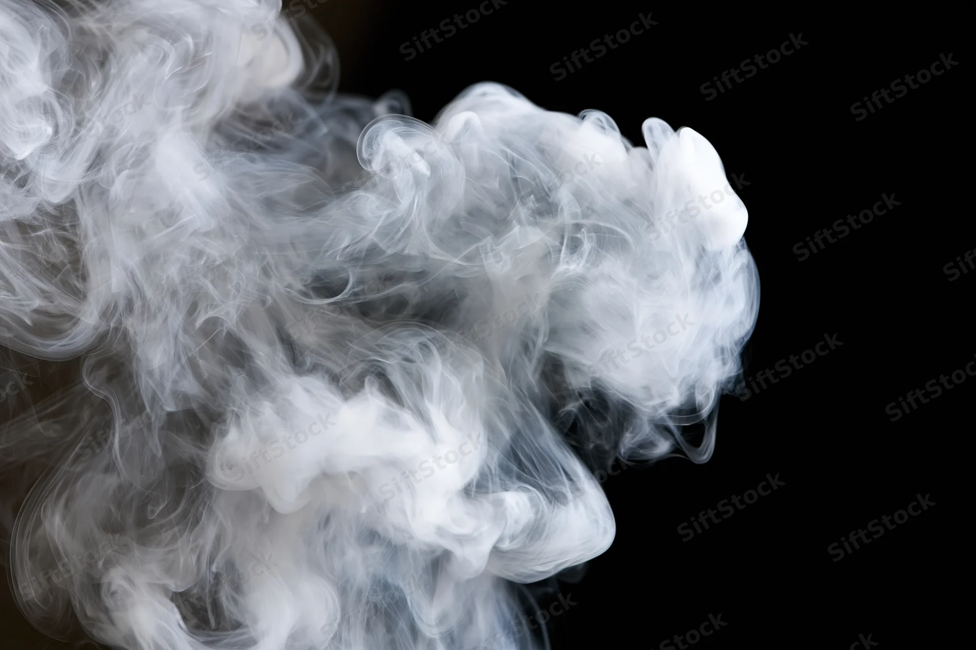 White smoke curling and billowing upward against a black background