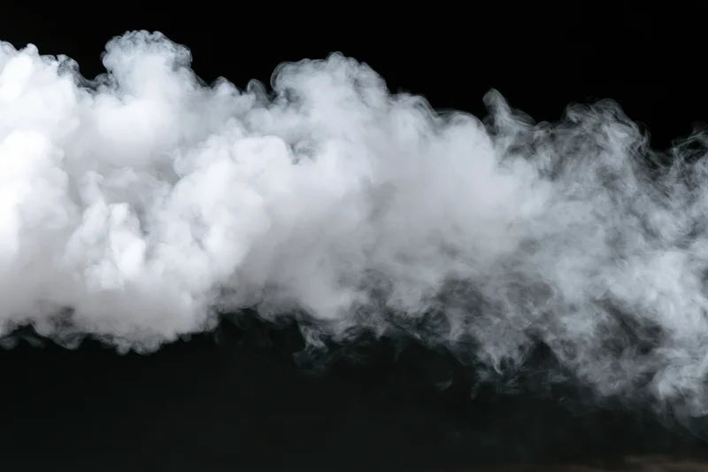 White smoke drifting horizontally across black background