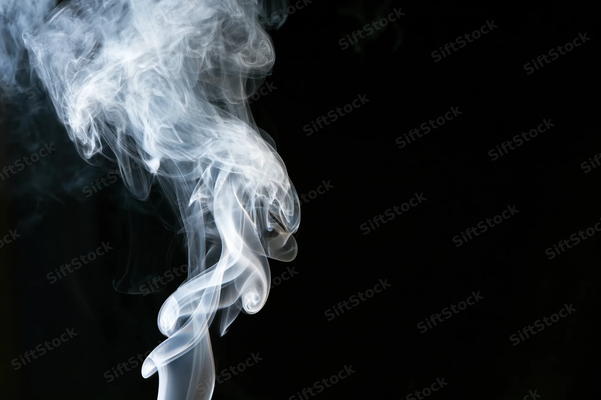 White smoke curling upward against a black background