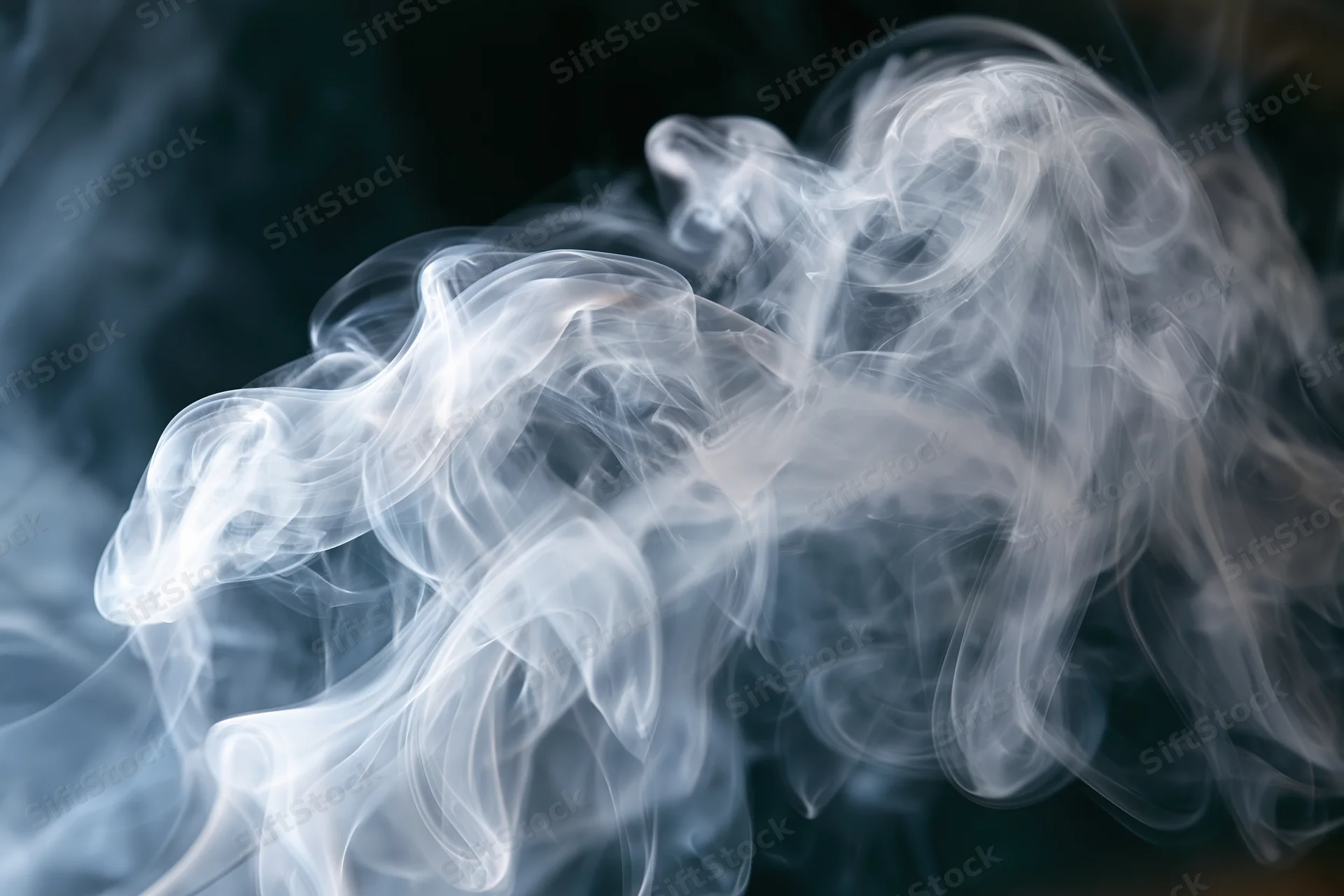 Wispy white smoke curling and swirling in layered tendrils against a dark background