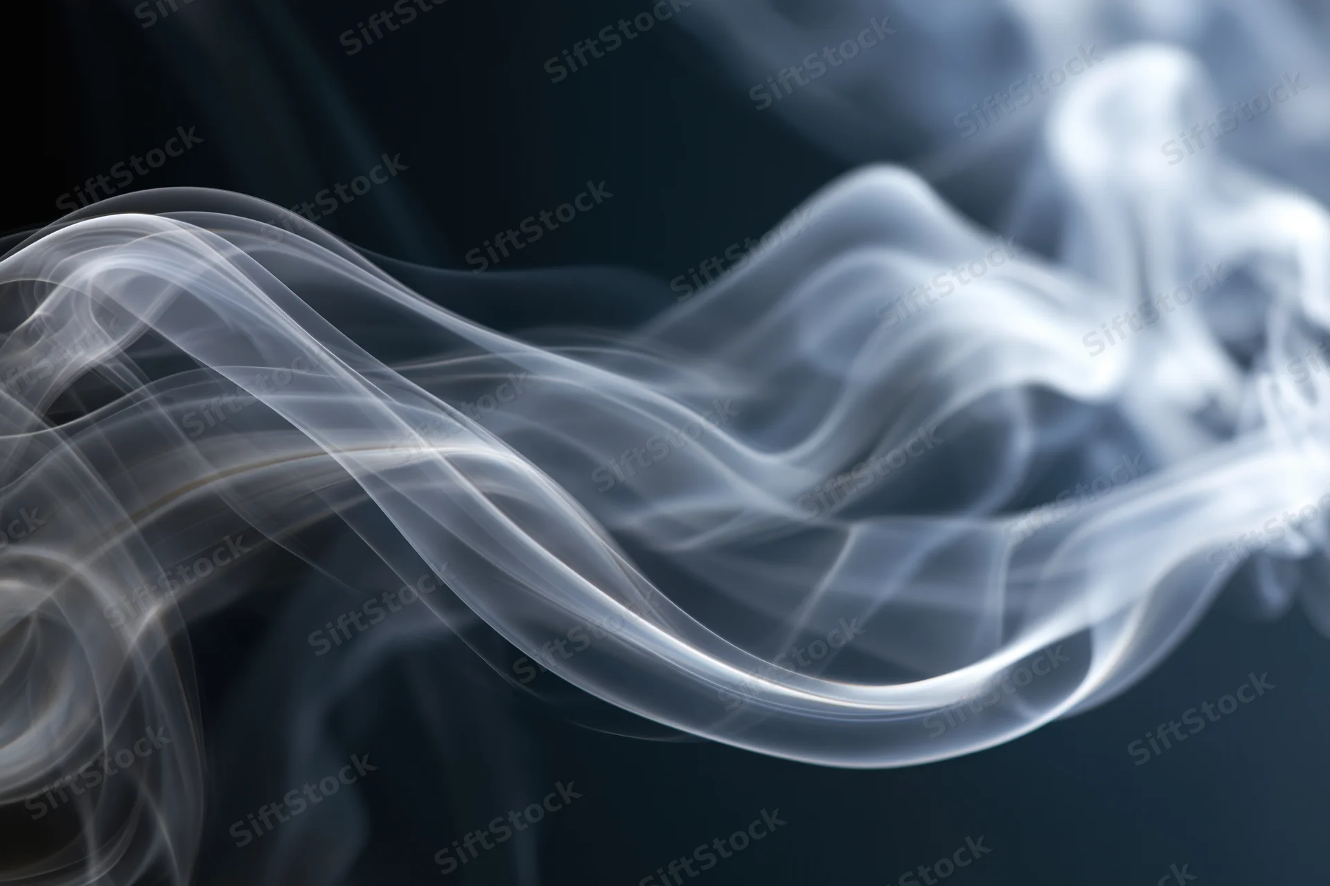 White smoke swirling in layered tendrils against a dark background
