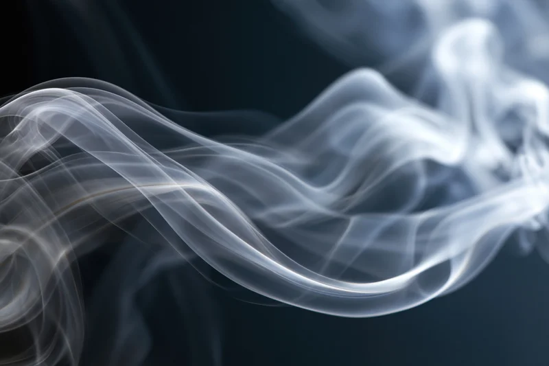 White smoke swirling in layered tendrils against a dark background