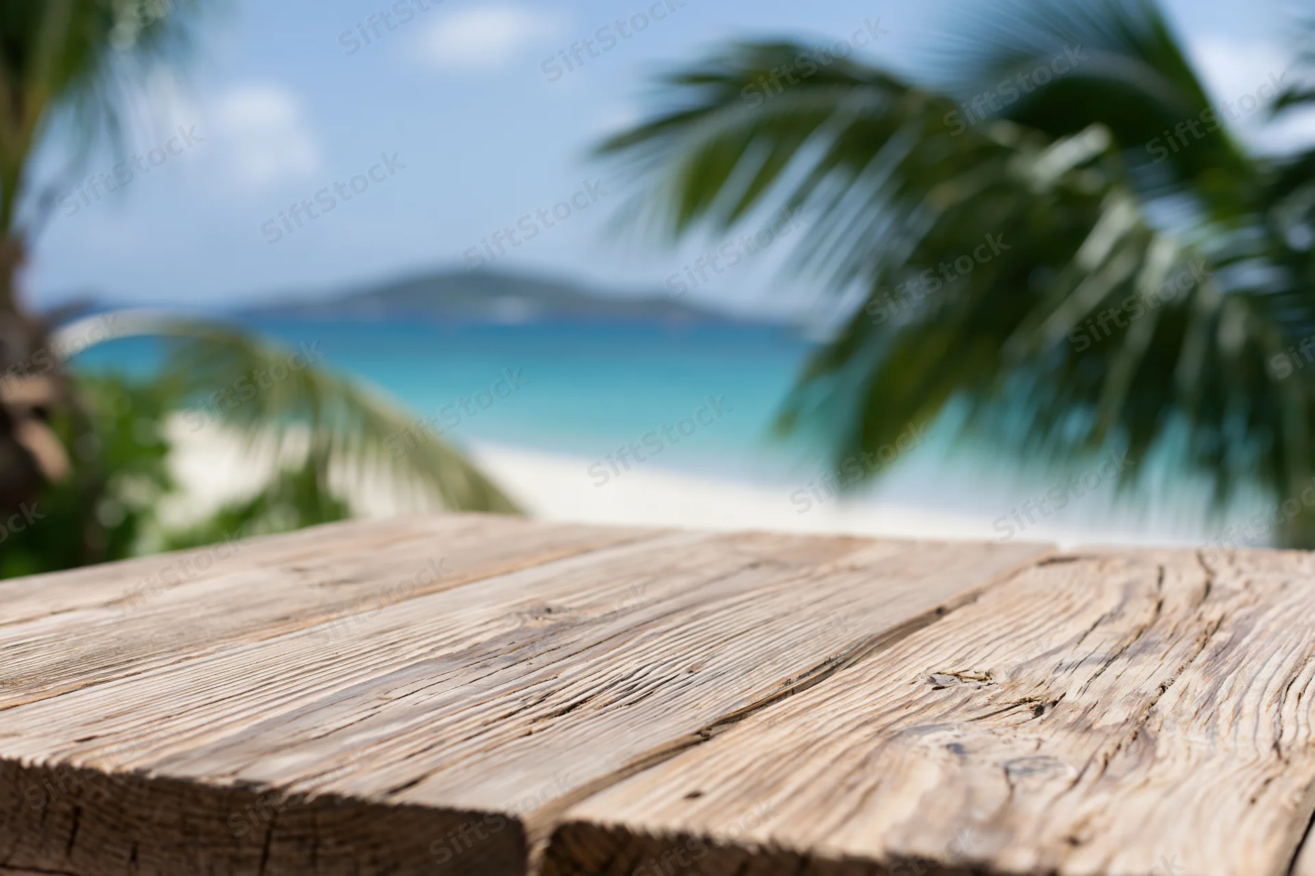 Wooden table surface in front of tropical beach with palm trees and ocean view