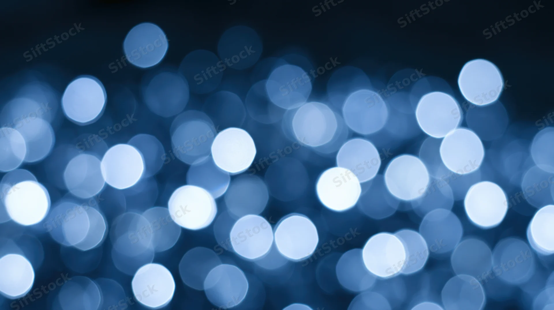 Blurred blue lights creating a soft bokeh effect against a dark background