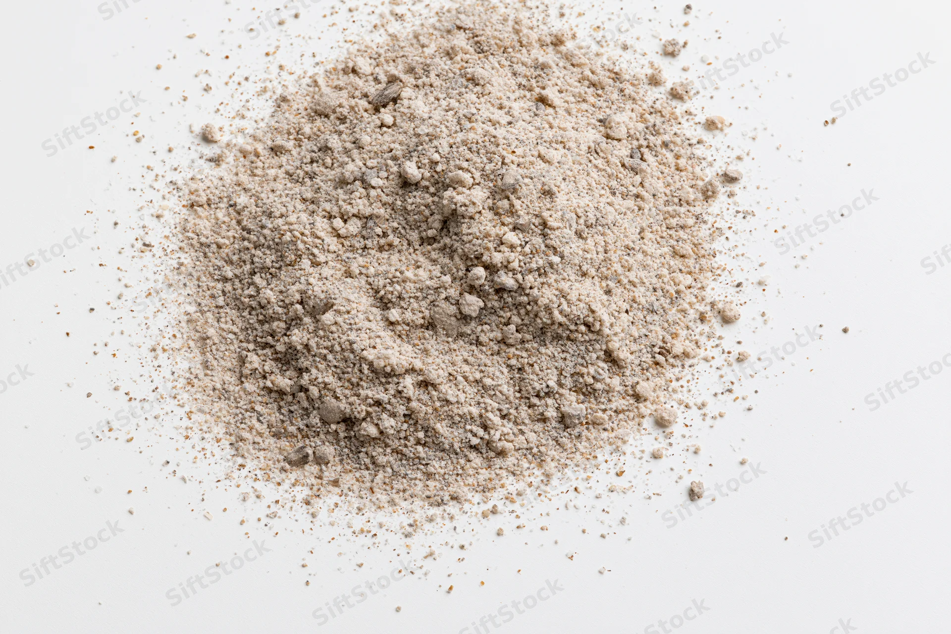 Pile of beige granular powder on white surface