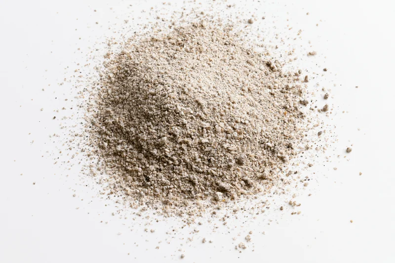 Pile of beige granular powder on white background