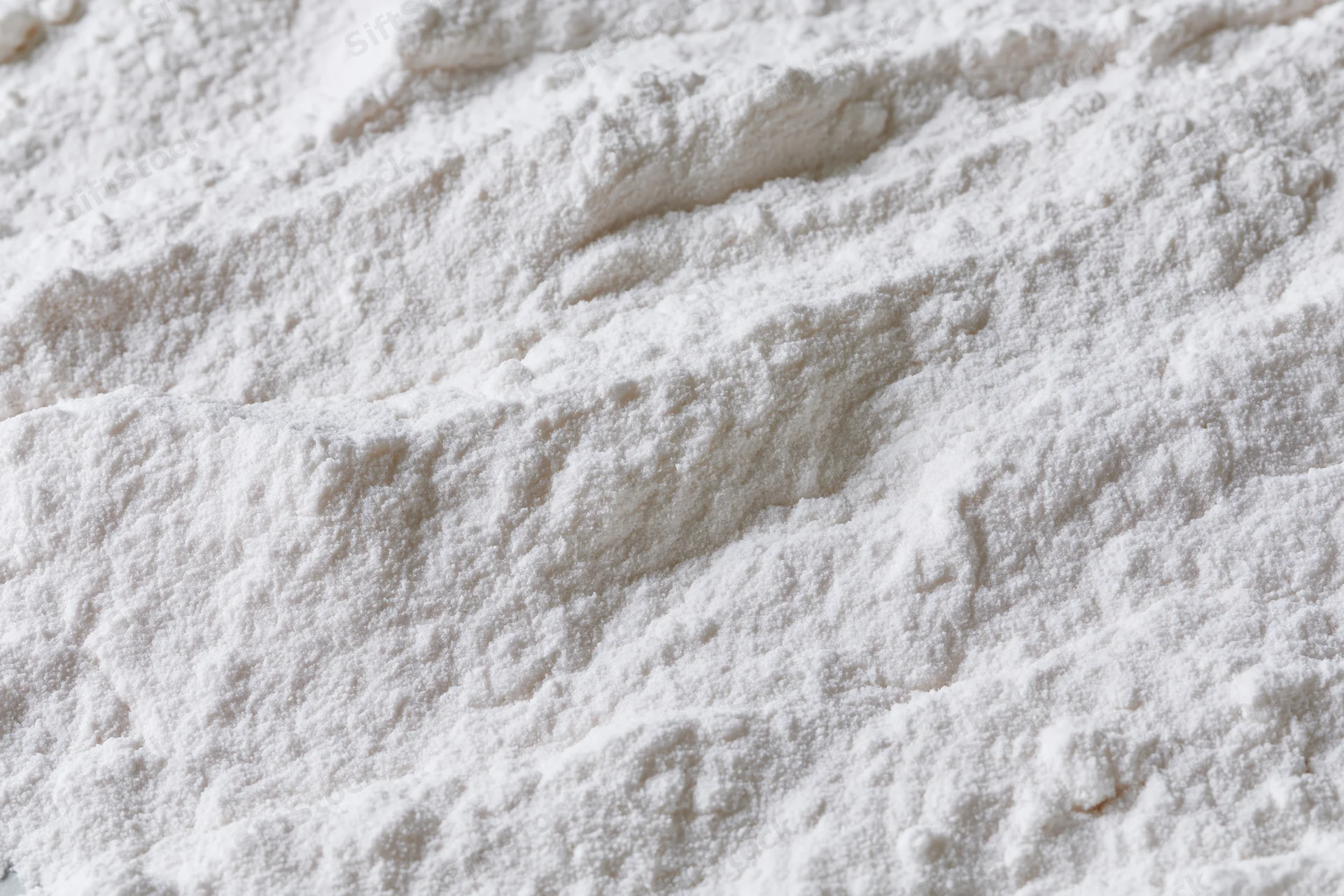Closeup of white flour powder texture in a pile on a flat surface