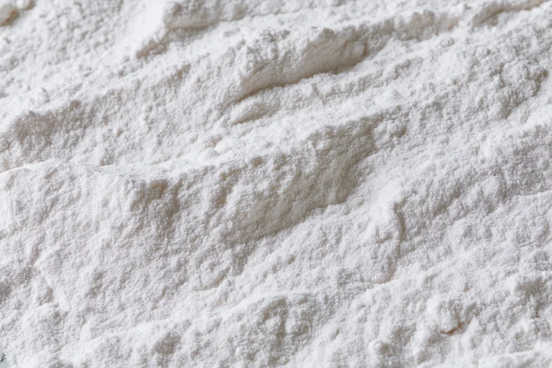 Closeup of white flour powder texture in a pile on a flat surface