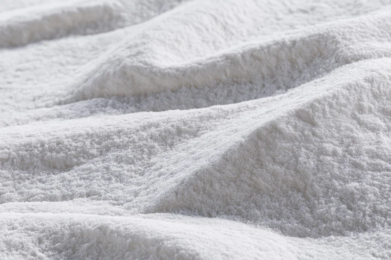 Closeup of white plush towel fabric with soft textured loops and folds