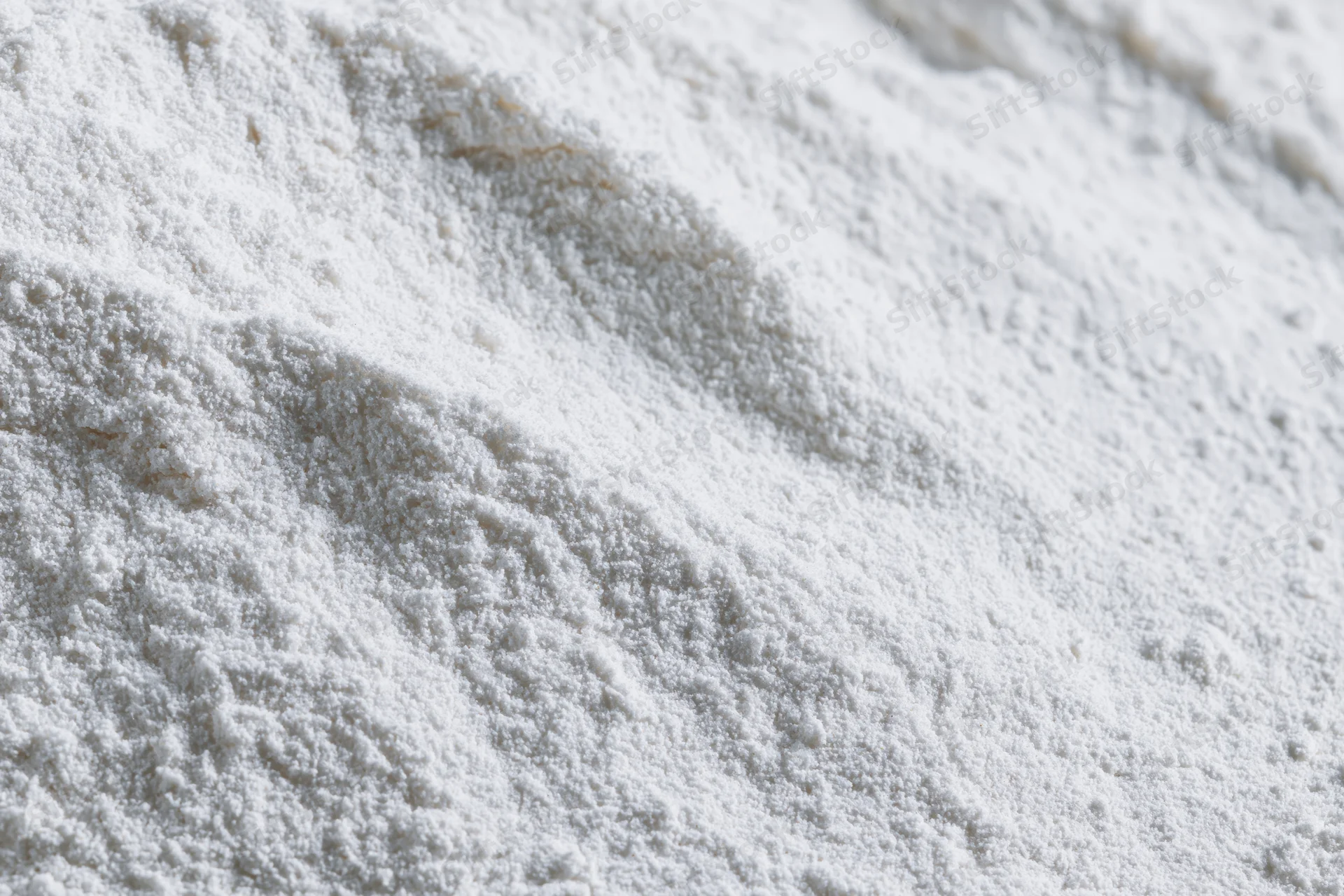 Closeup of white flour powder texture in a pile on a flat surface