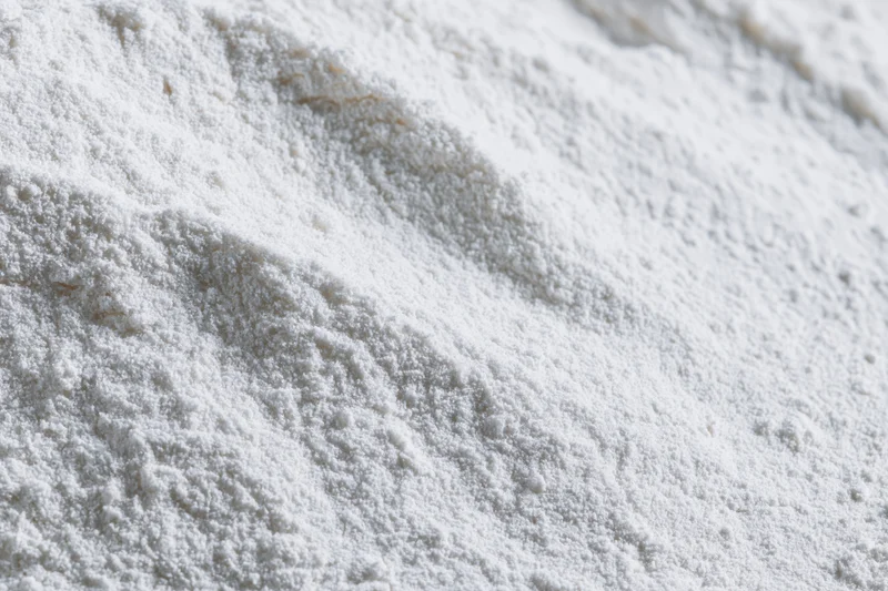 Closeup of white flour powder texture in a pile on a flat surface