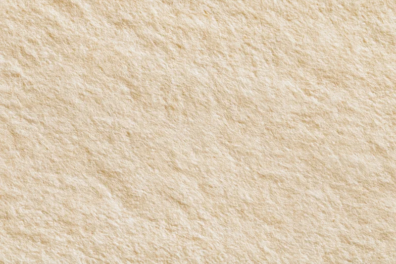 Close-up of beige textured stone surface filling the frame