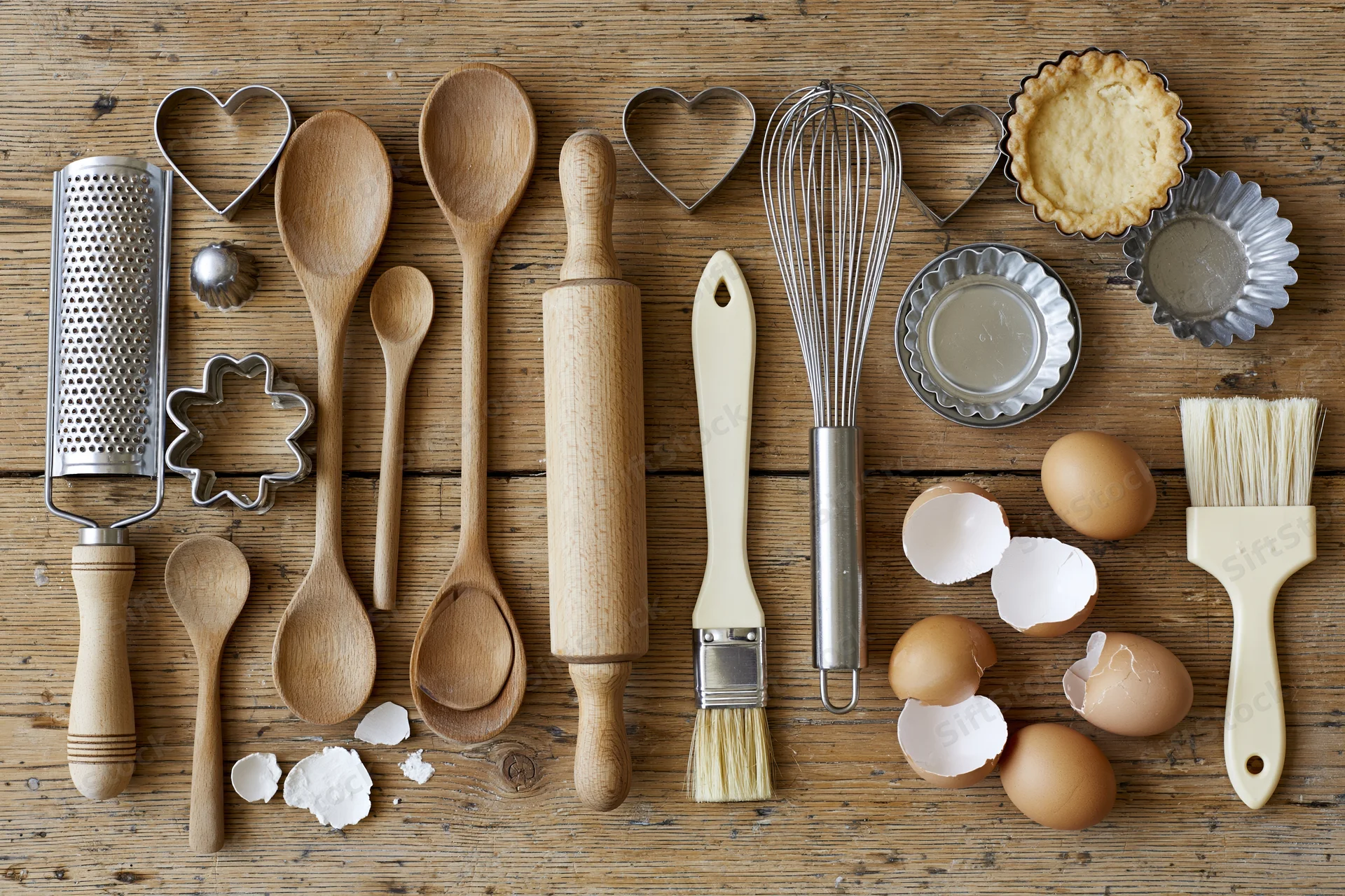 Baking utensils and ingredients arranged on a wooden surface