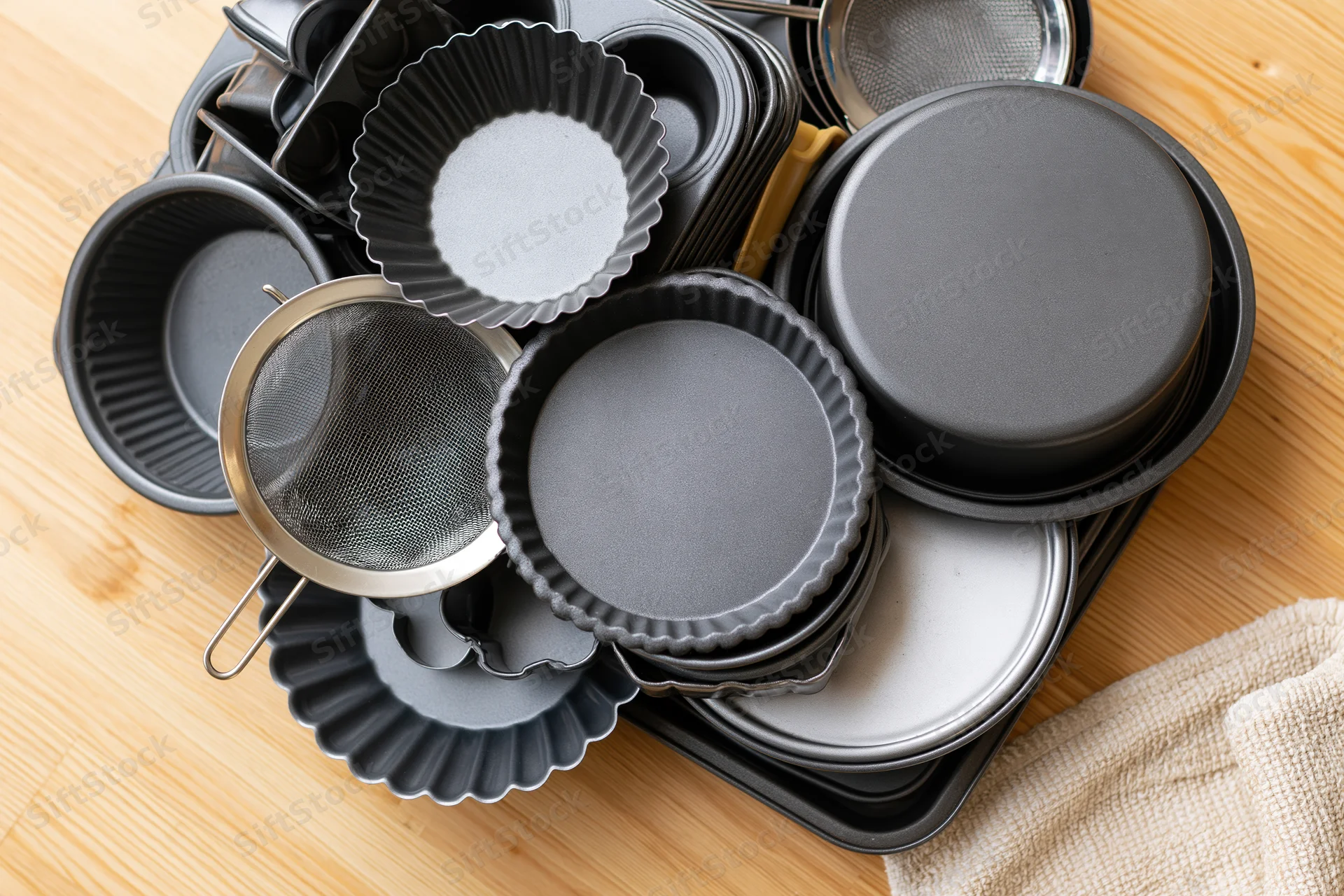 Stack of baking pans and molds on wooden countertop