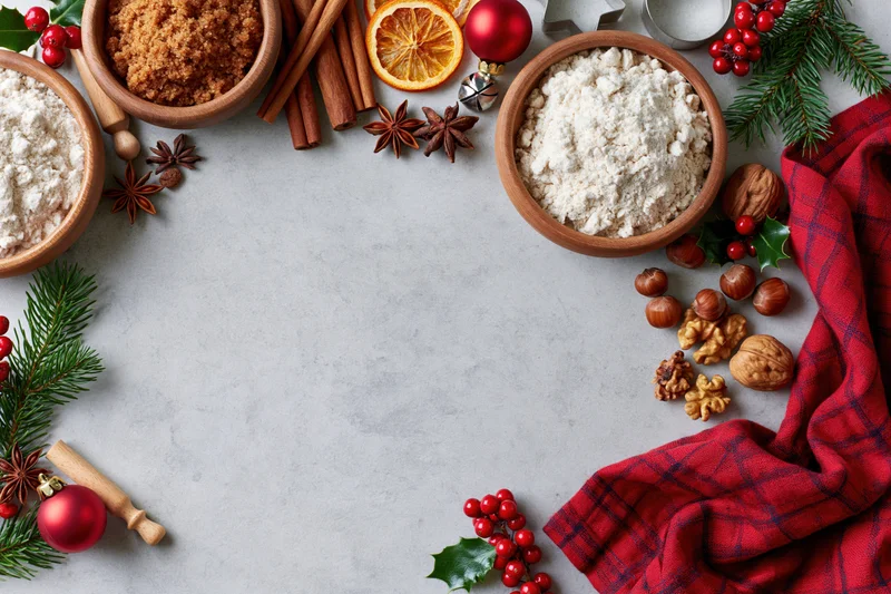Christmas baking ingredients arranged on countertop with festive decorations and copyspace