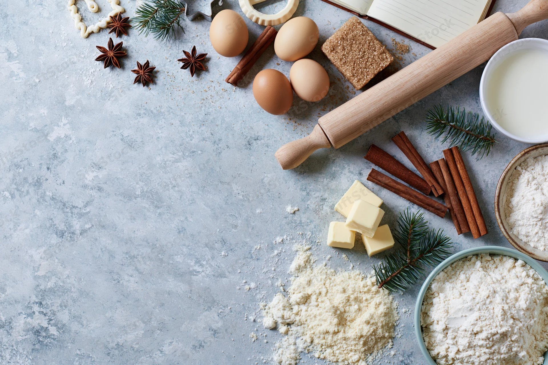 Baking ingredients arranged on a countertop with festive decorations and copyspace