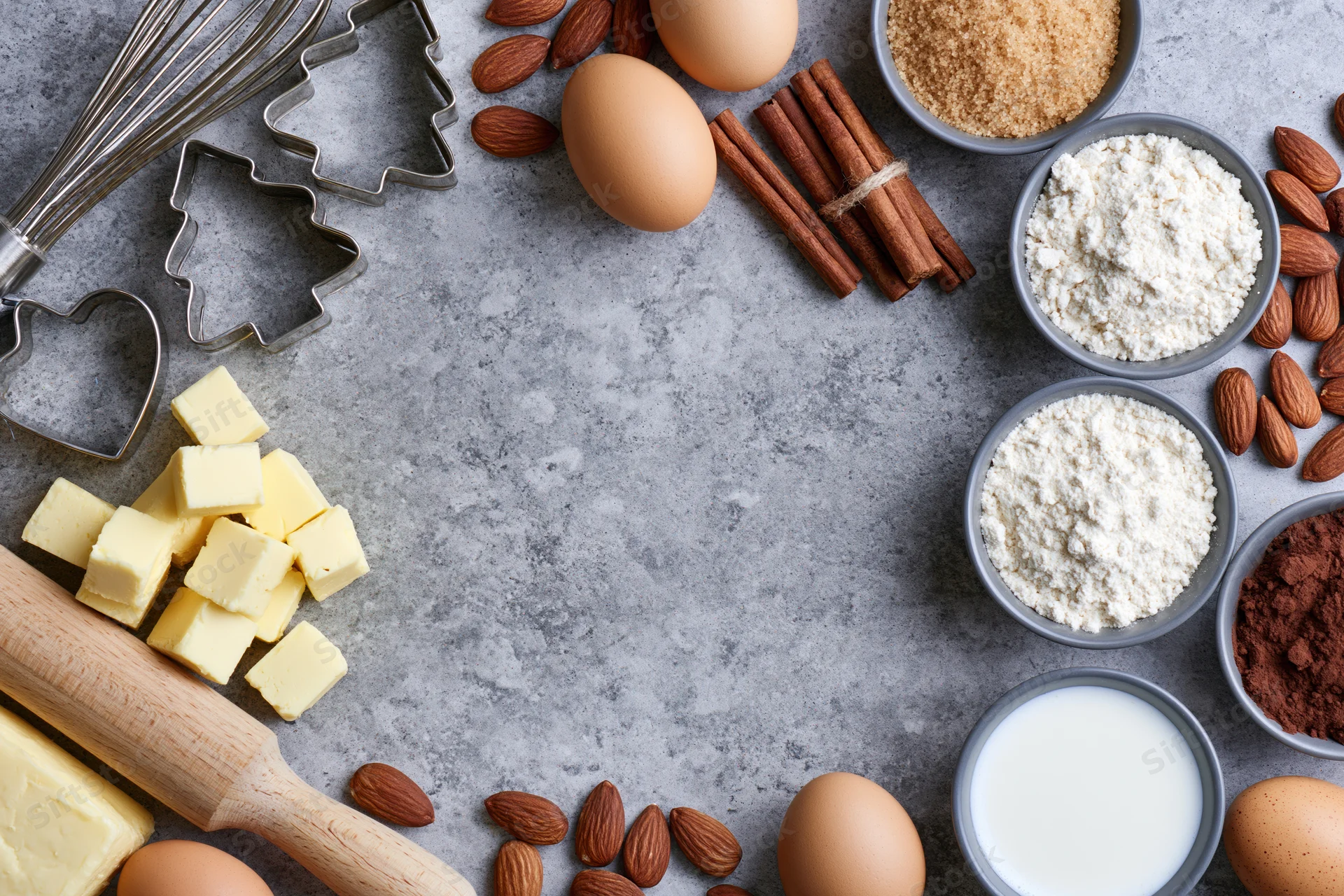 Baking ingredients arranged around a gray countertop with copyspace in center