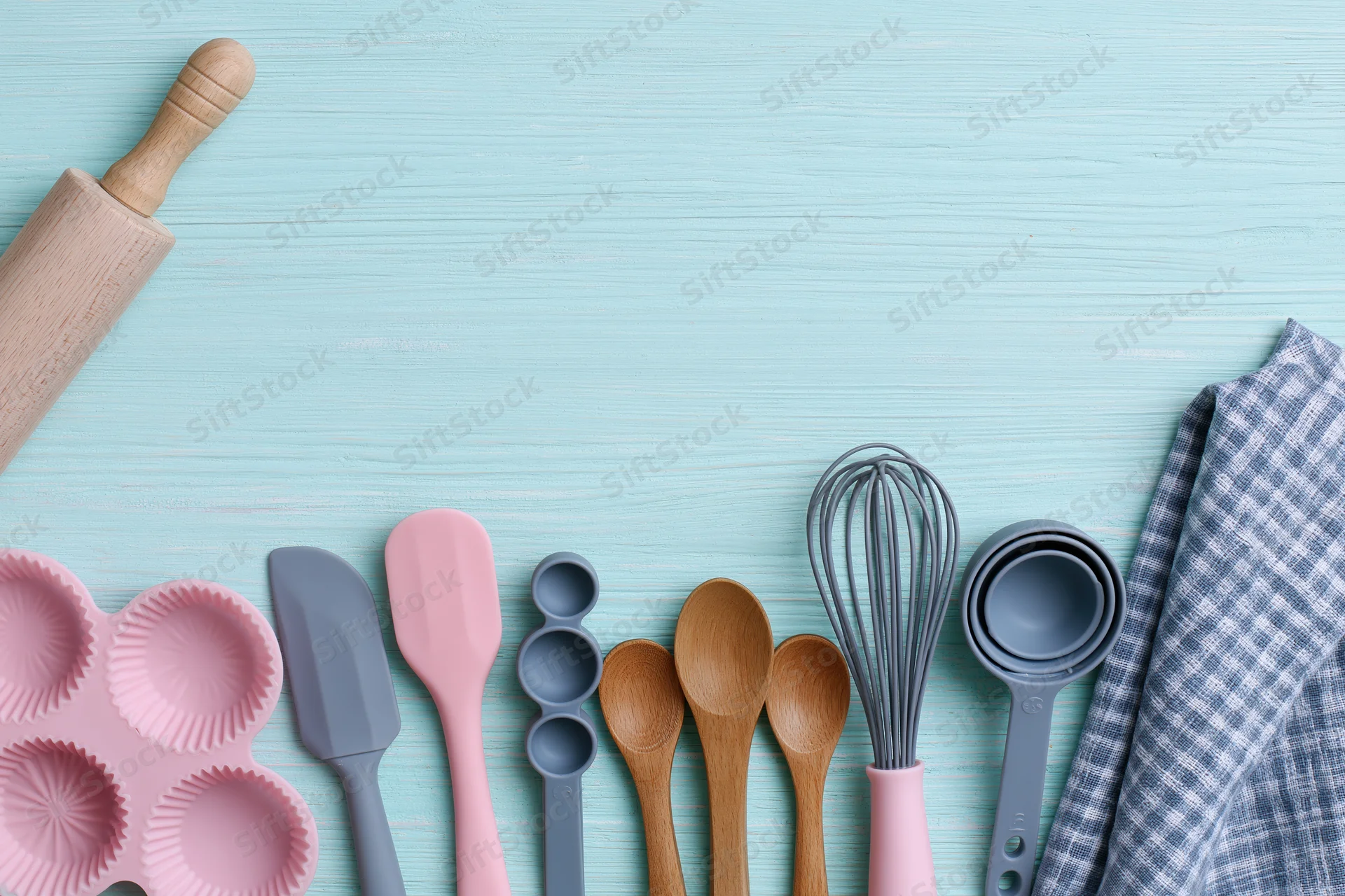 Baking utensils arranged on a blue wooden surface with copyspace