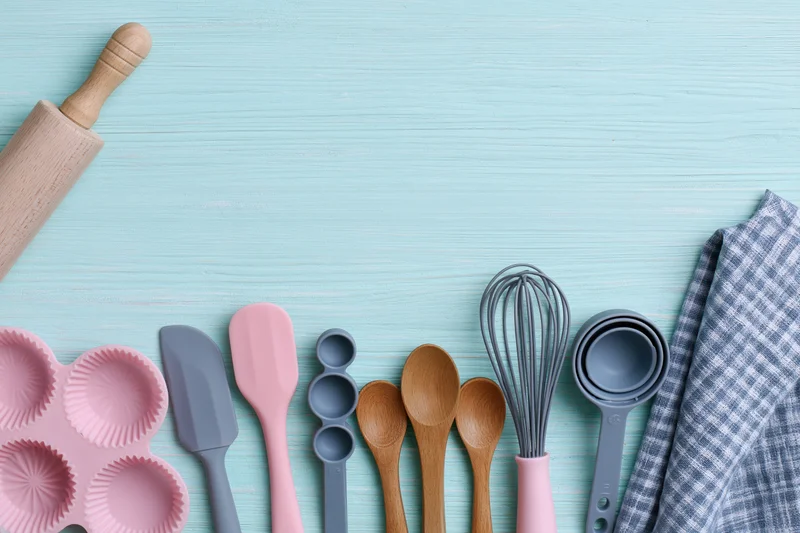 Baking utensils arranged on a blue wooden surface with copyspace