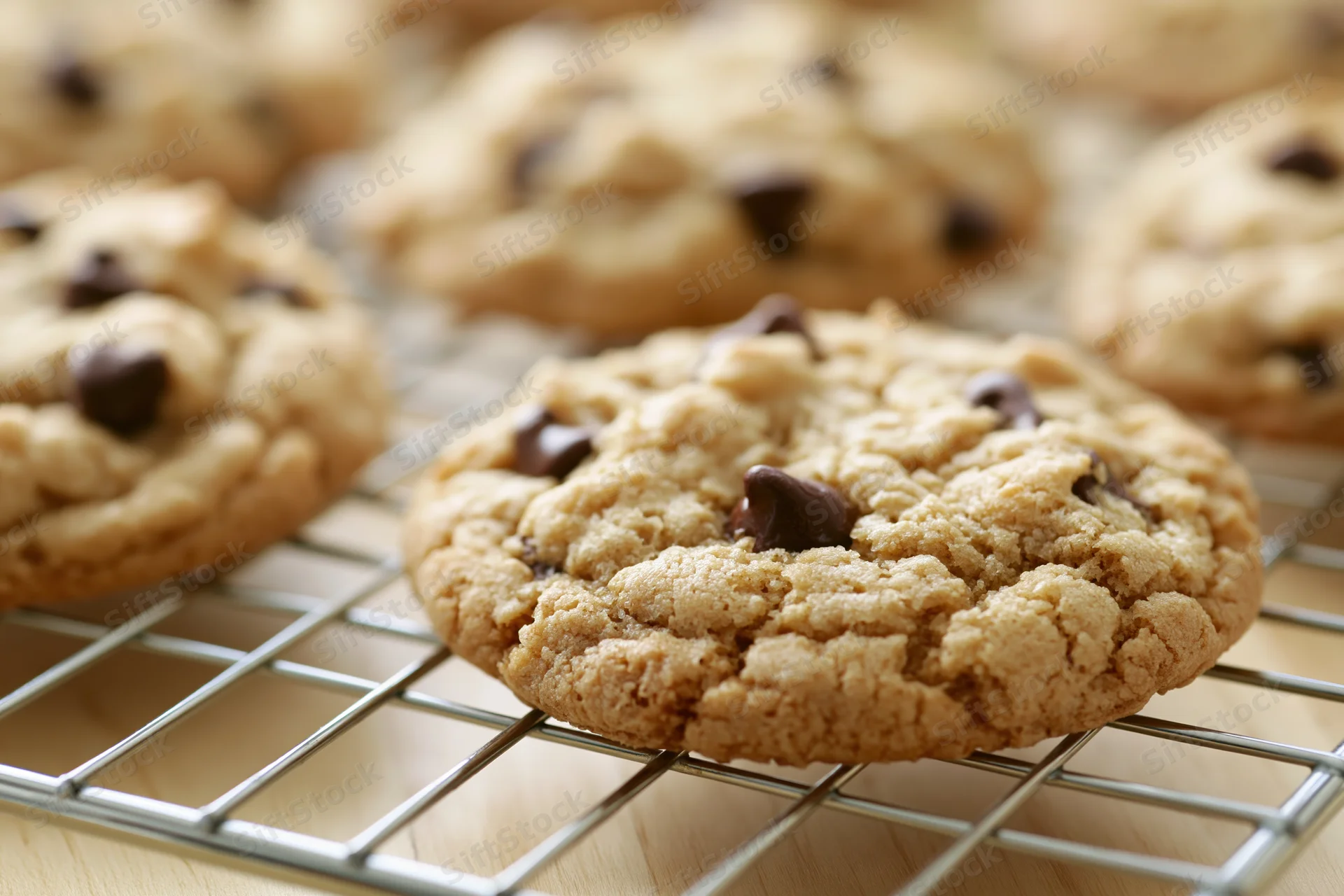 Chocolate chip cookies cooling on a wire rack in a kitchen