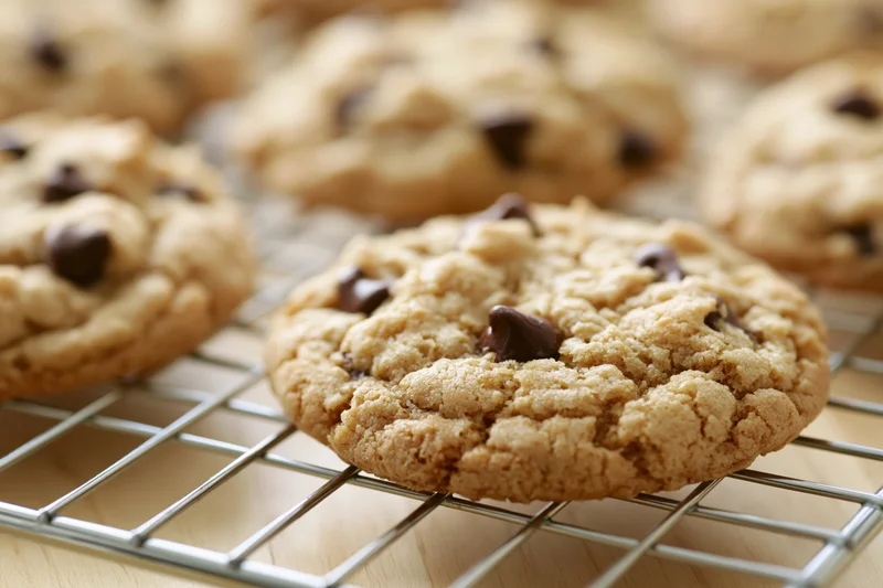 Chocolate chip cookies cooling on a wire rack in a kitchen