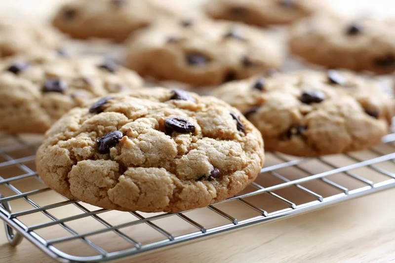 Chocolate chip cookies cooling on a wire rack in a kitchen