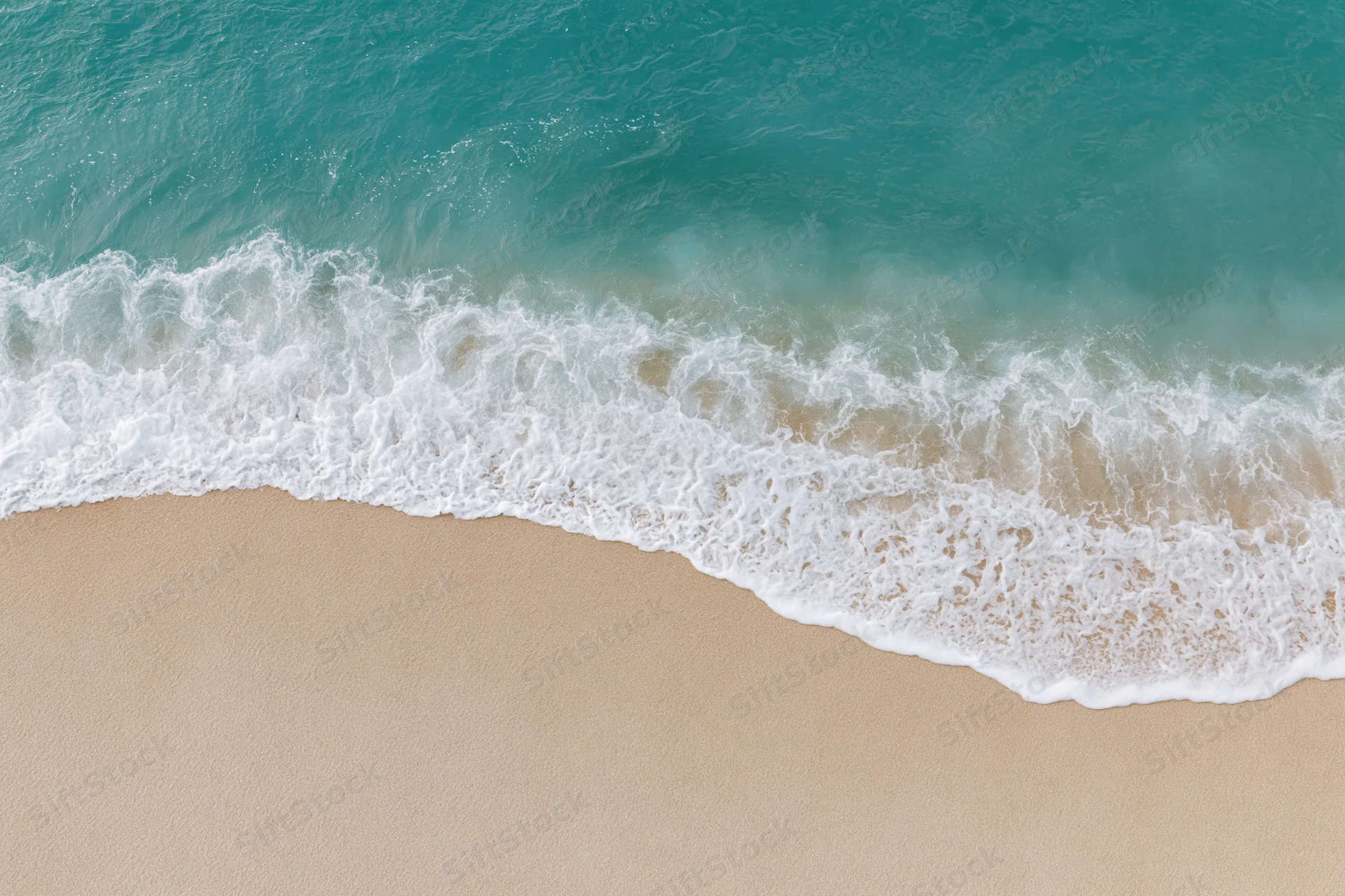 Waves breaking on sandy beach from above