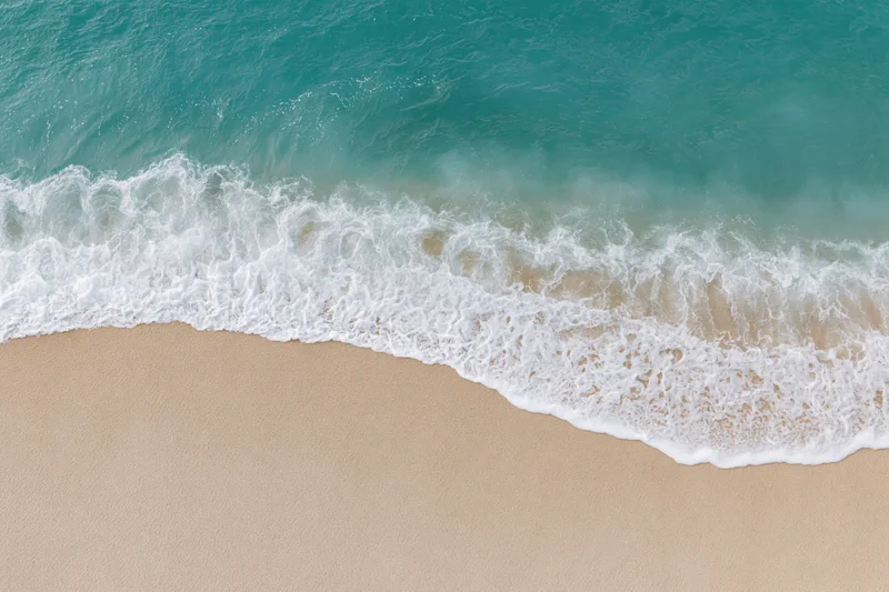 Waves breaking on sandy beach from above