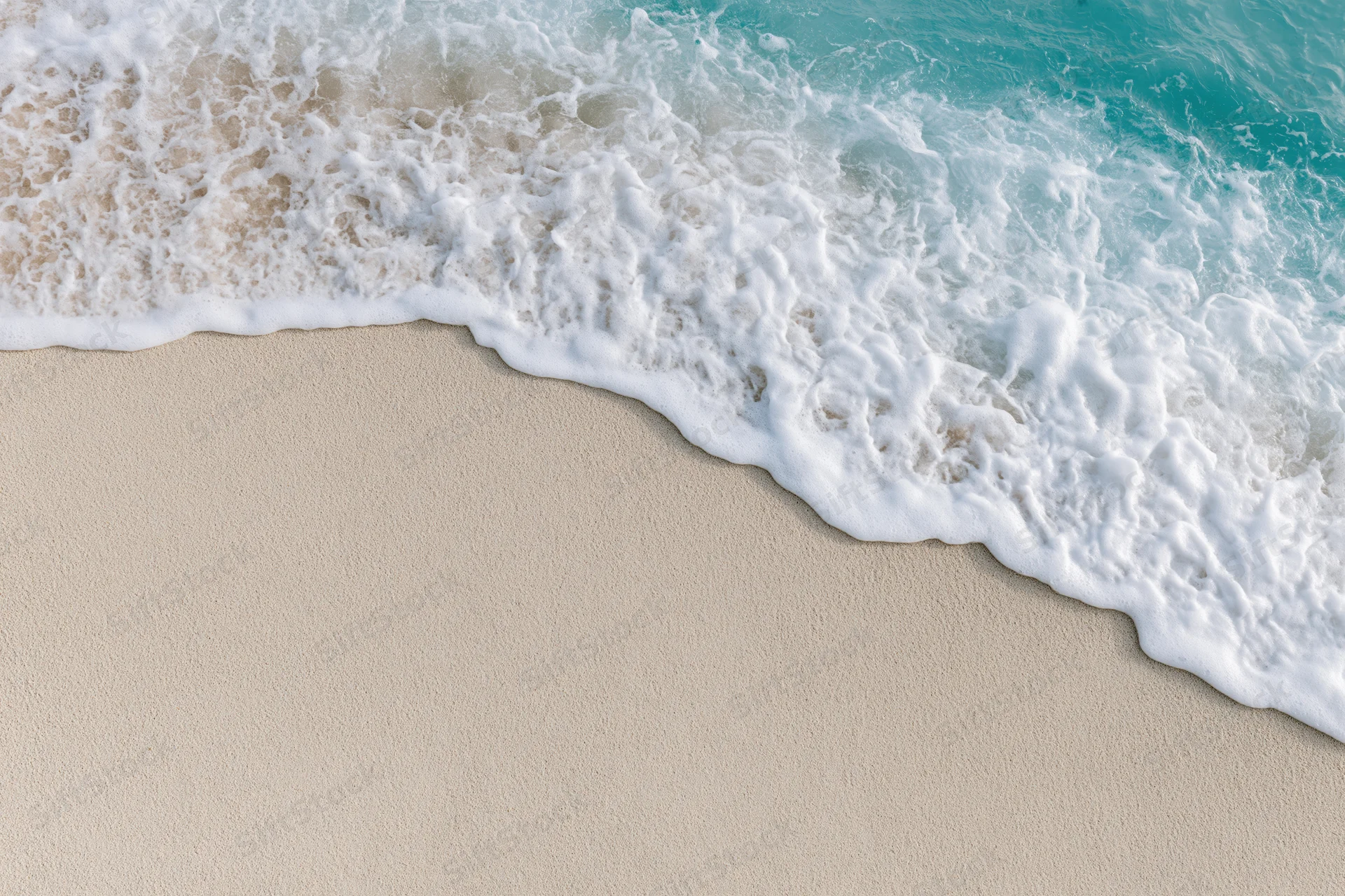 Gentle wave with white foam washing onto light sand beach