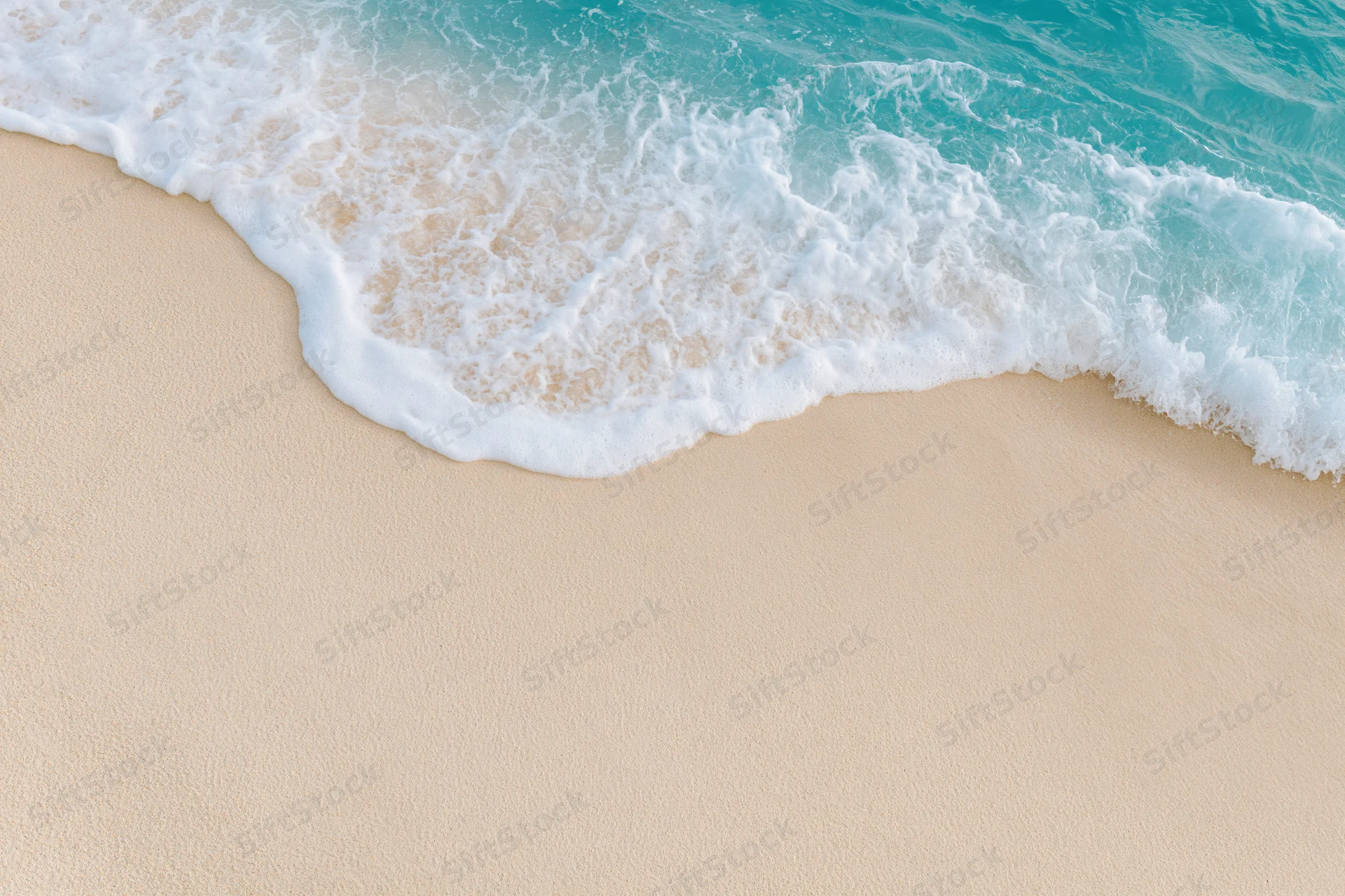 Gentle wave with white foam washing over smooth beige sand at the shoreline