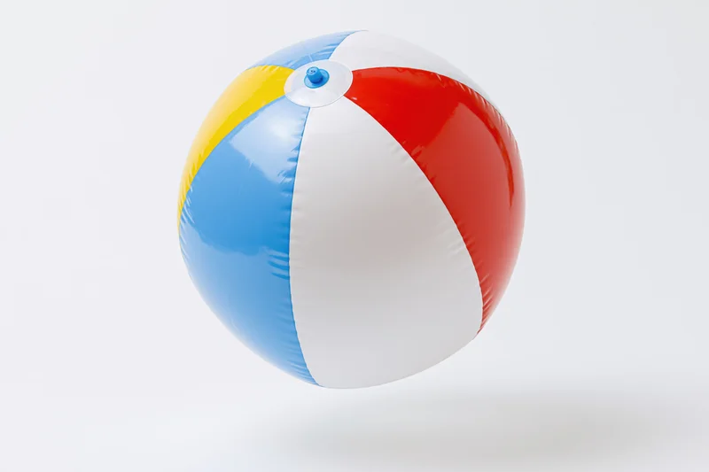 Colorful inflatable beachball floating against white background
