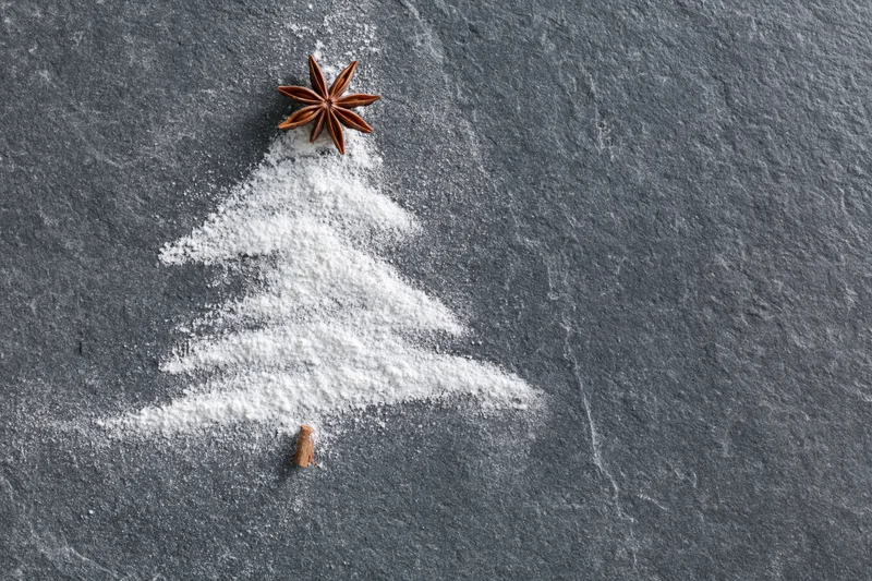 Sugar shaped as a christmas tree on slate with star anise and cinnamon stick