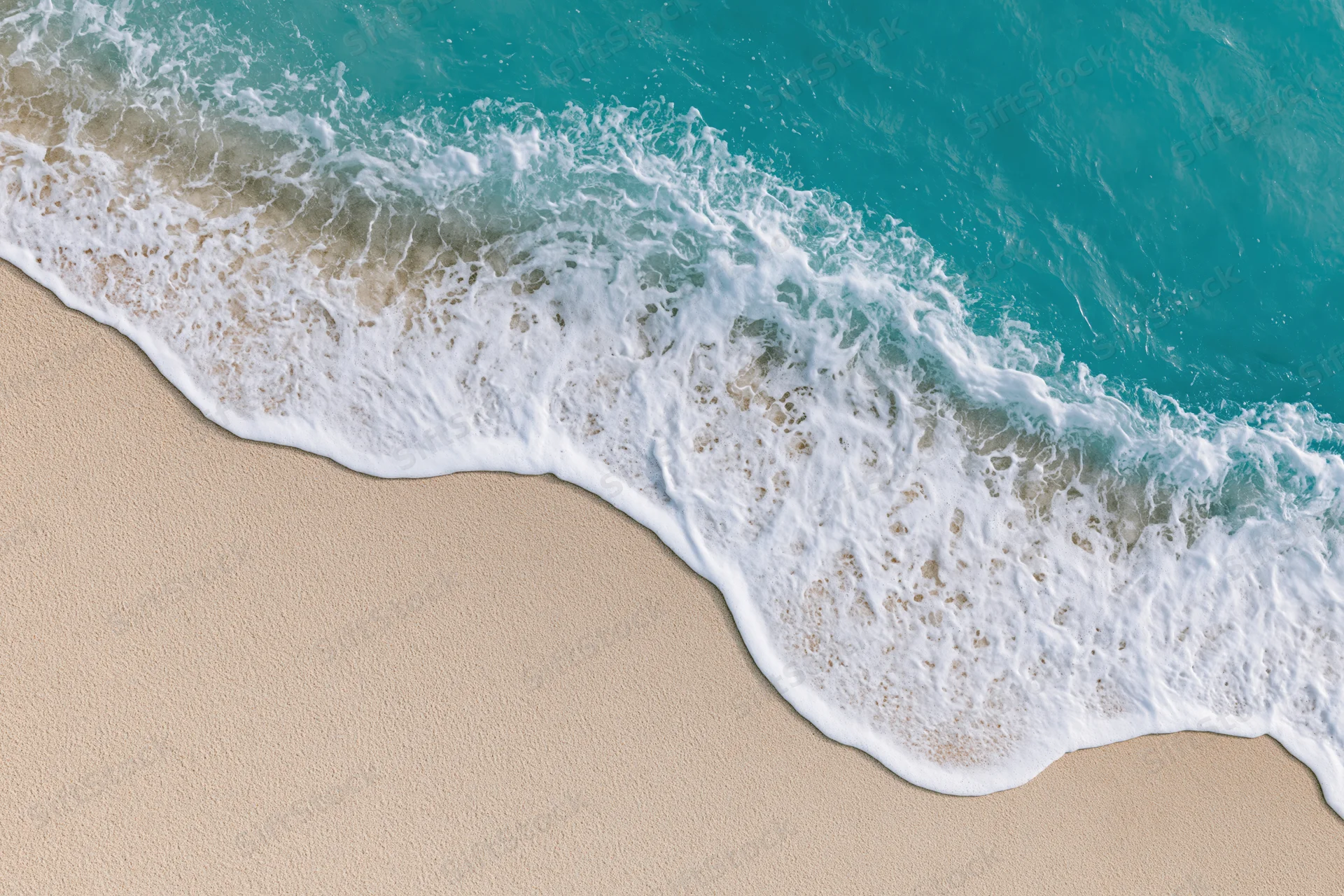 Wave breaking on sandy beach with white foam and turquoise water