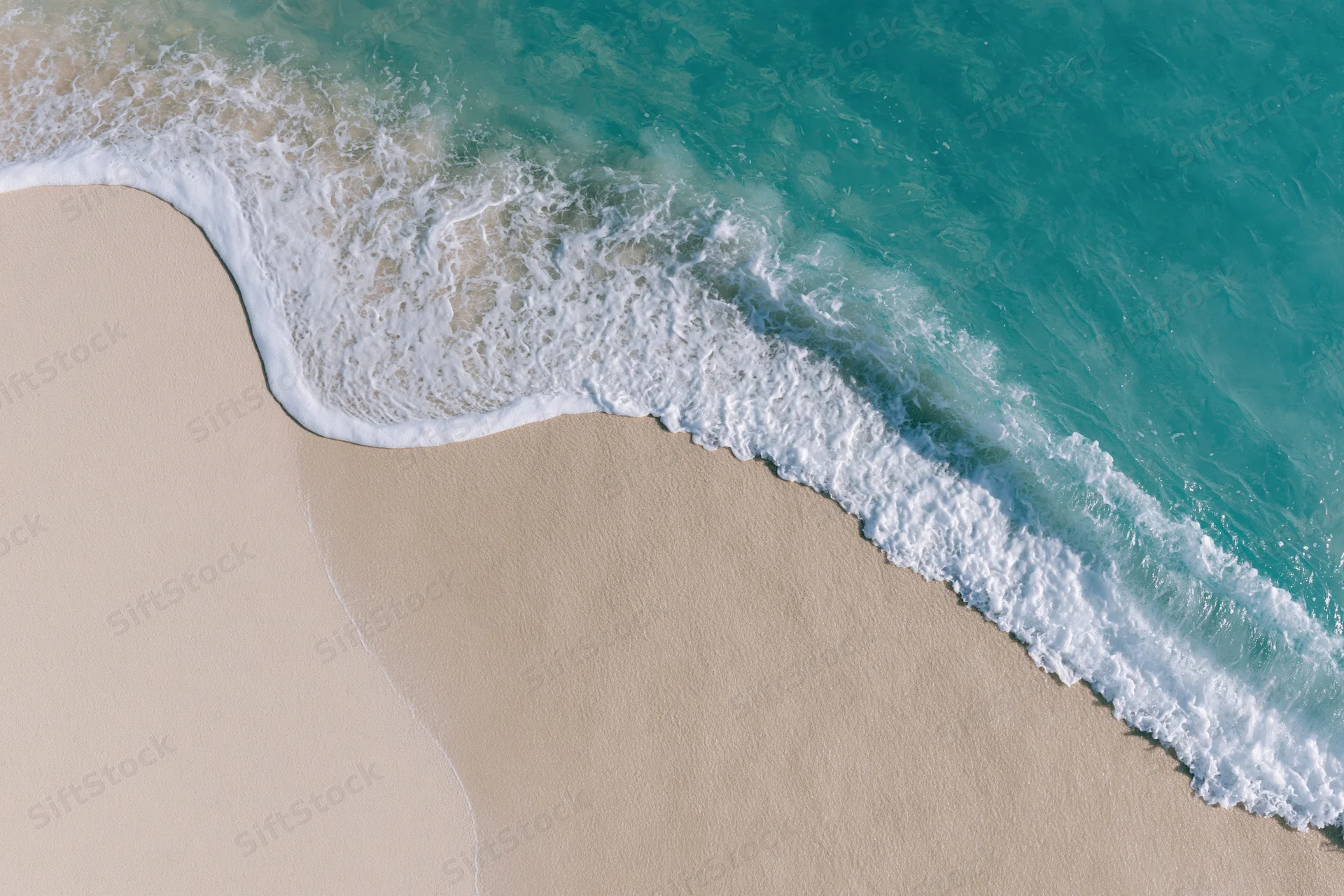 Waves breaking on sandy beach from above