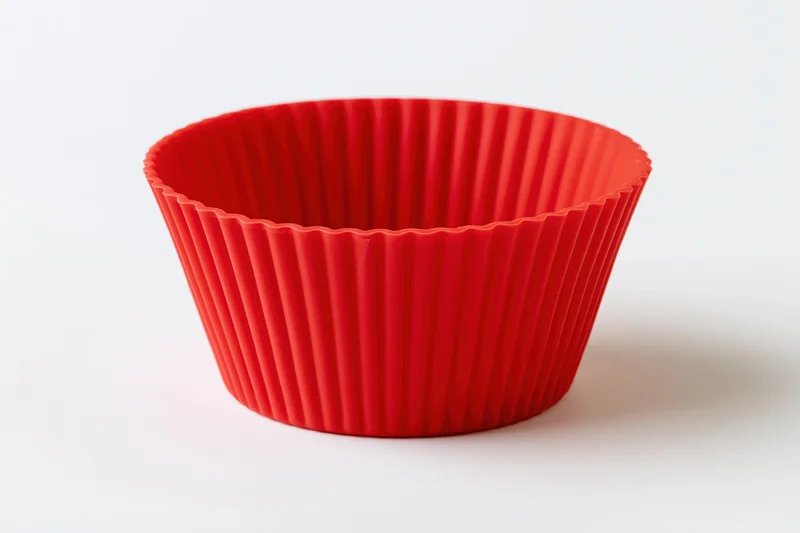 Red silicone cupcake mold on white background