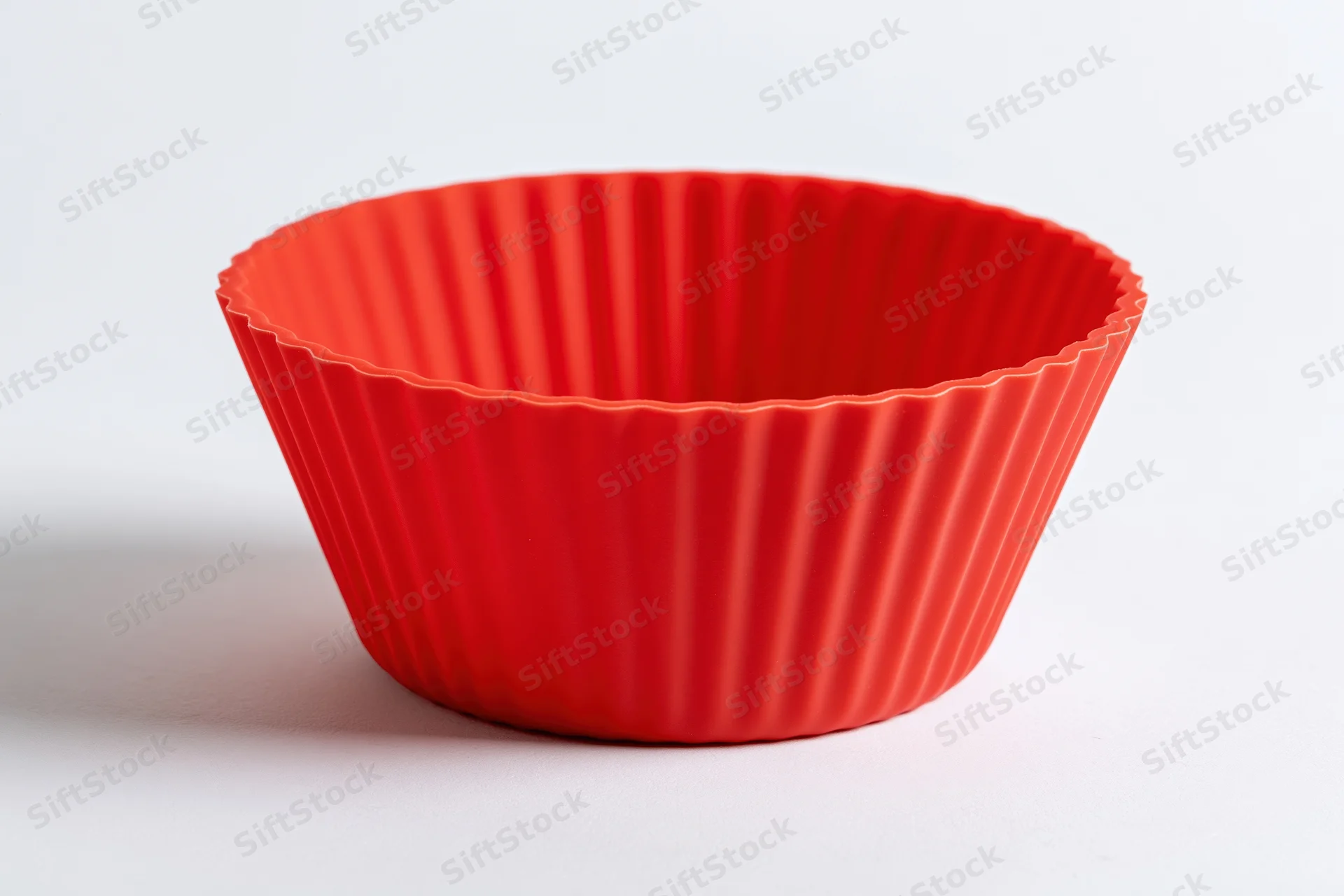Red silicone cupcake mold on white surface