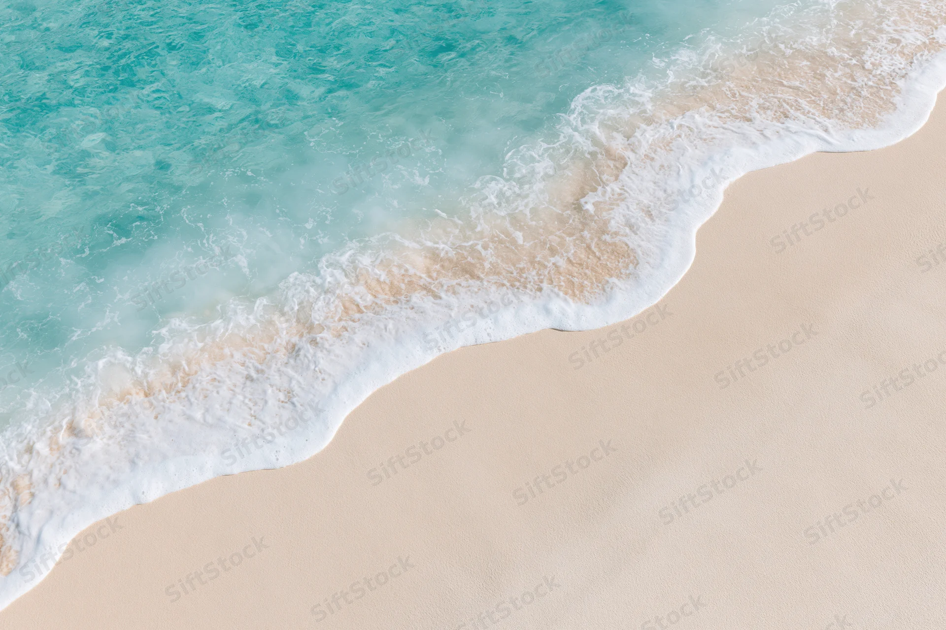Waves rolling onto a sandy beach from above