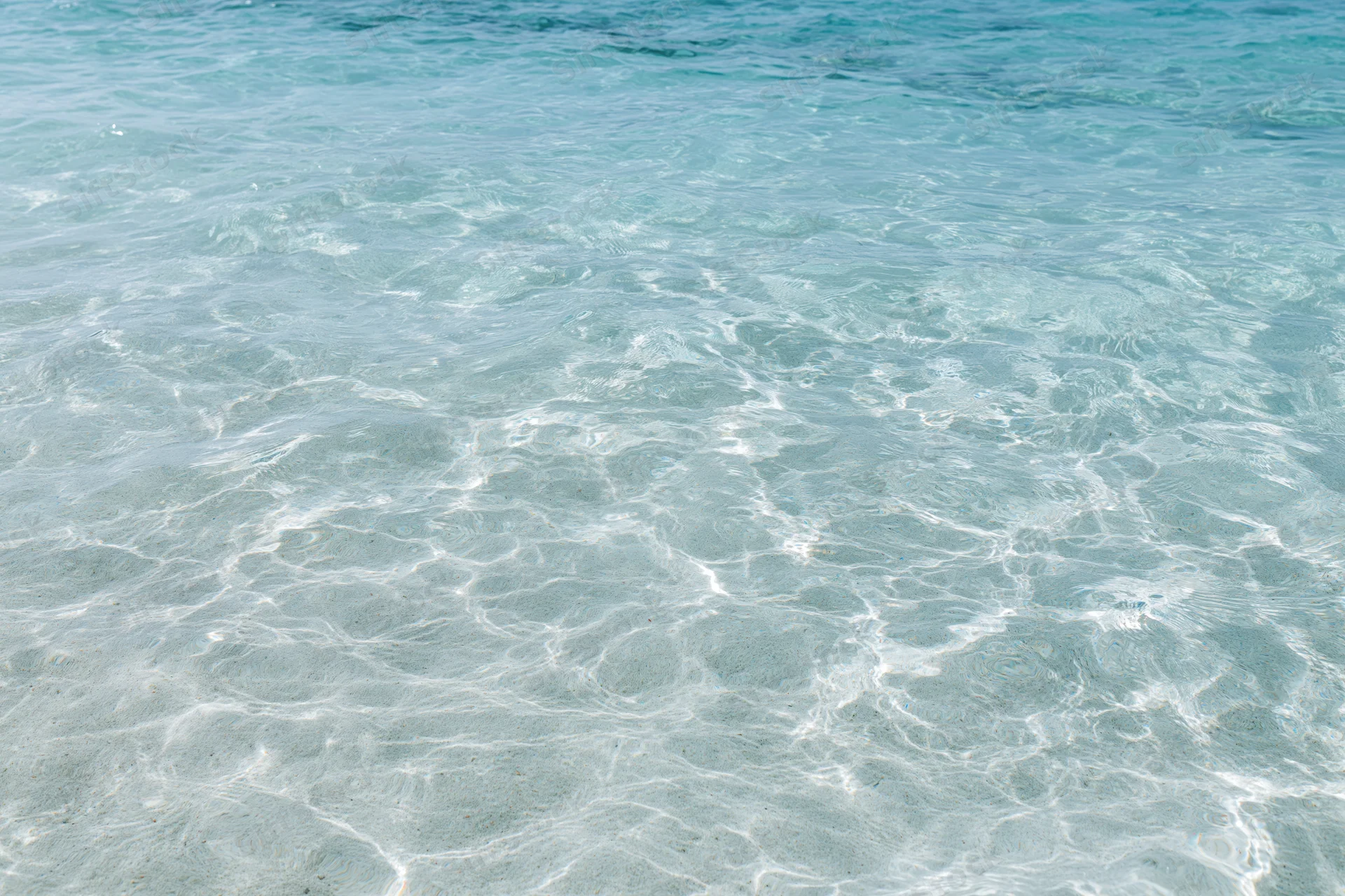 Clear ocean water rippling over sandy seabed in shallow coastal area