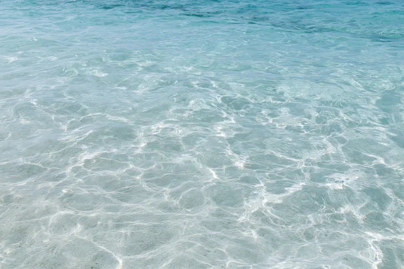 Clear ocean water rippling over sandy seabed in shallow coastal area