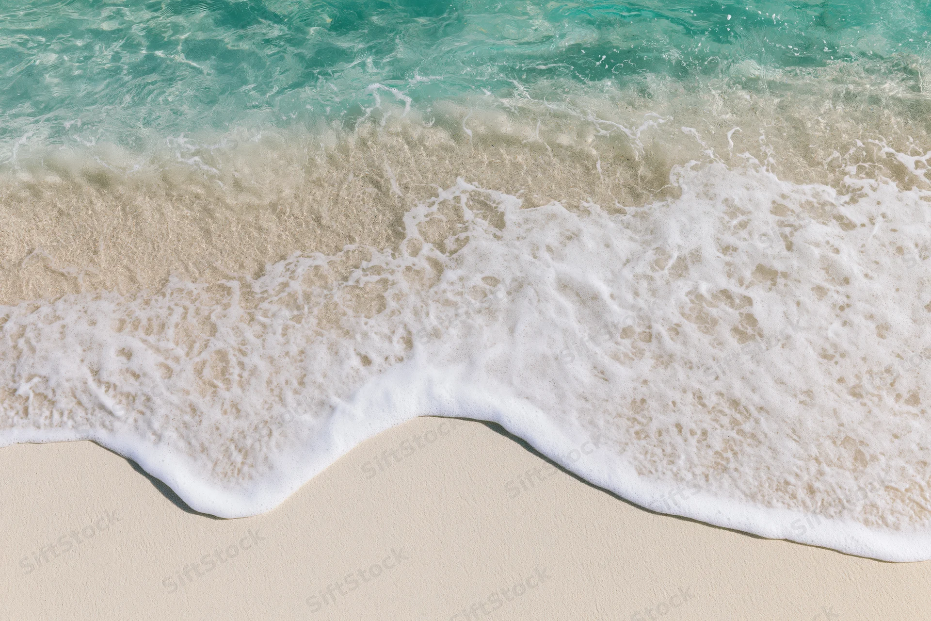 Turquoise ocean waves breaking onto white sandy beach