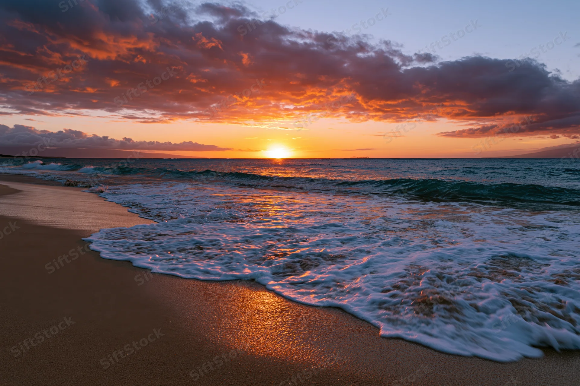 Sunset over ocean waves washing onto sandy beach at twilight
