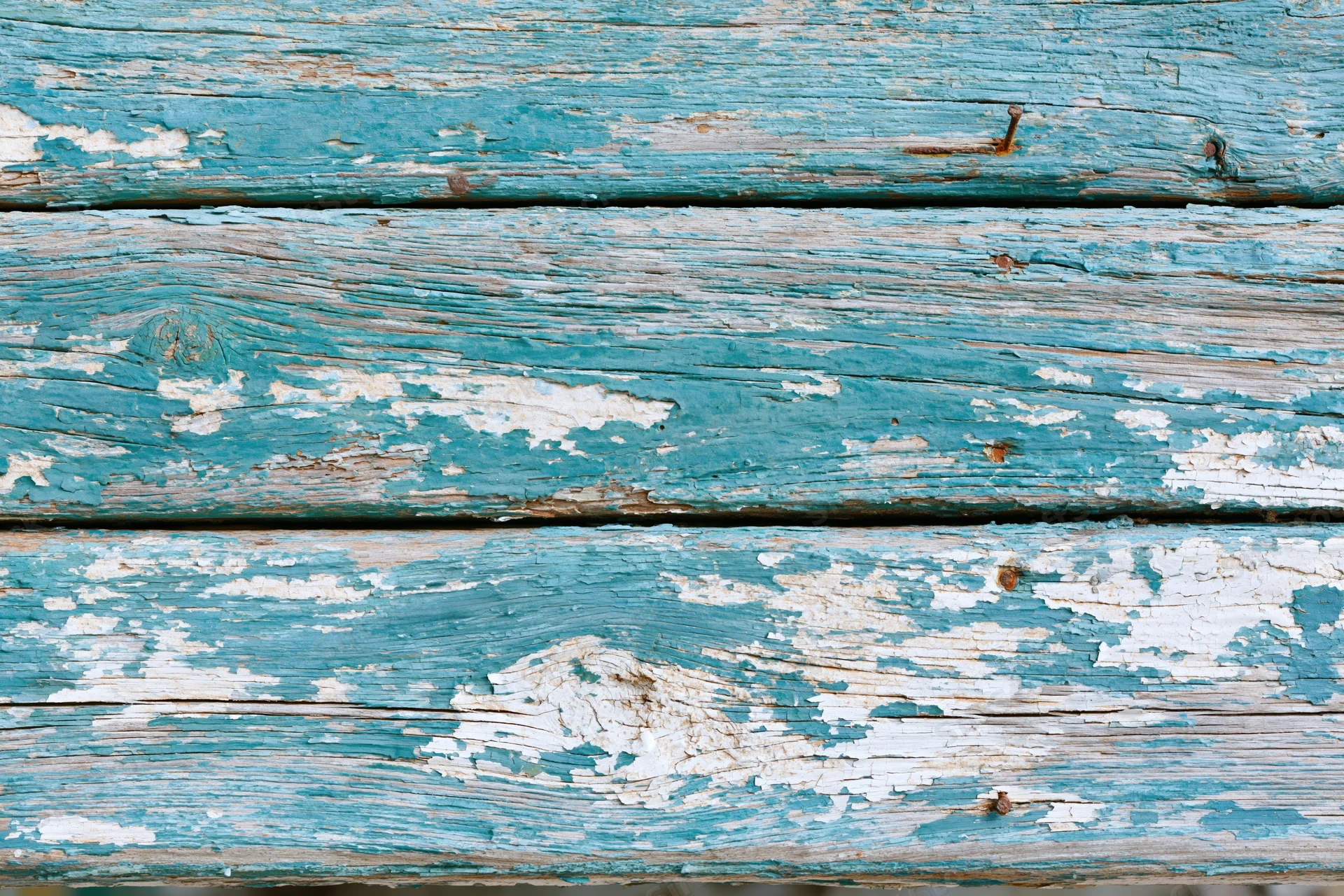 Weathered blue-painted wooden planks with peeling paint and visible grain