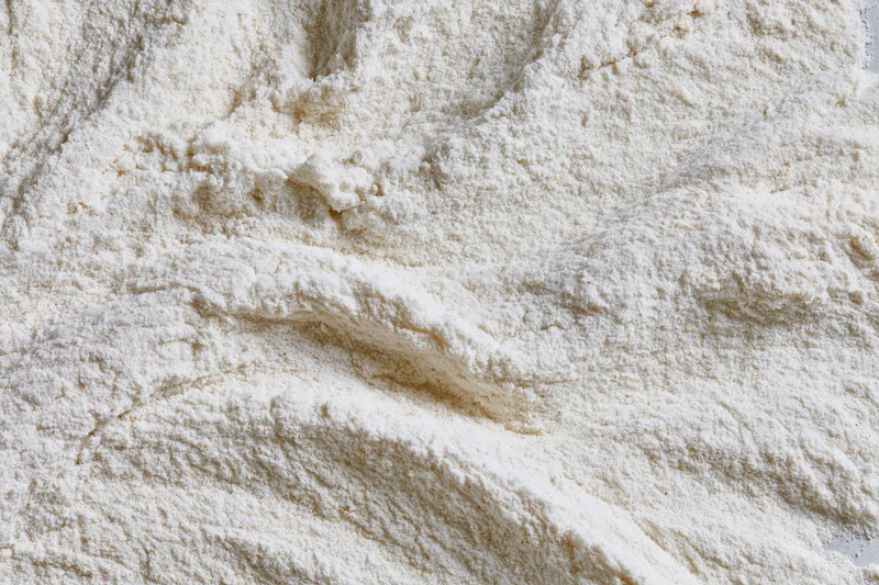 Closeup of white flour pile showing fine granular texture and soft surface details