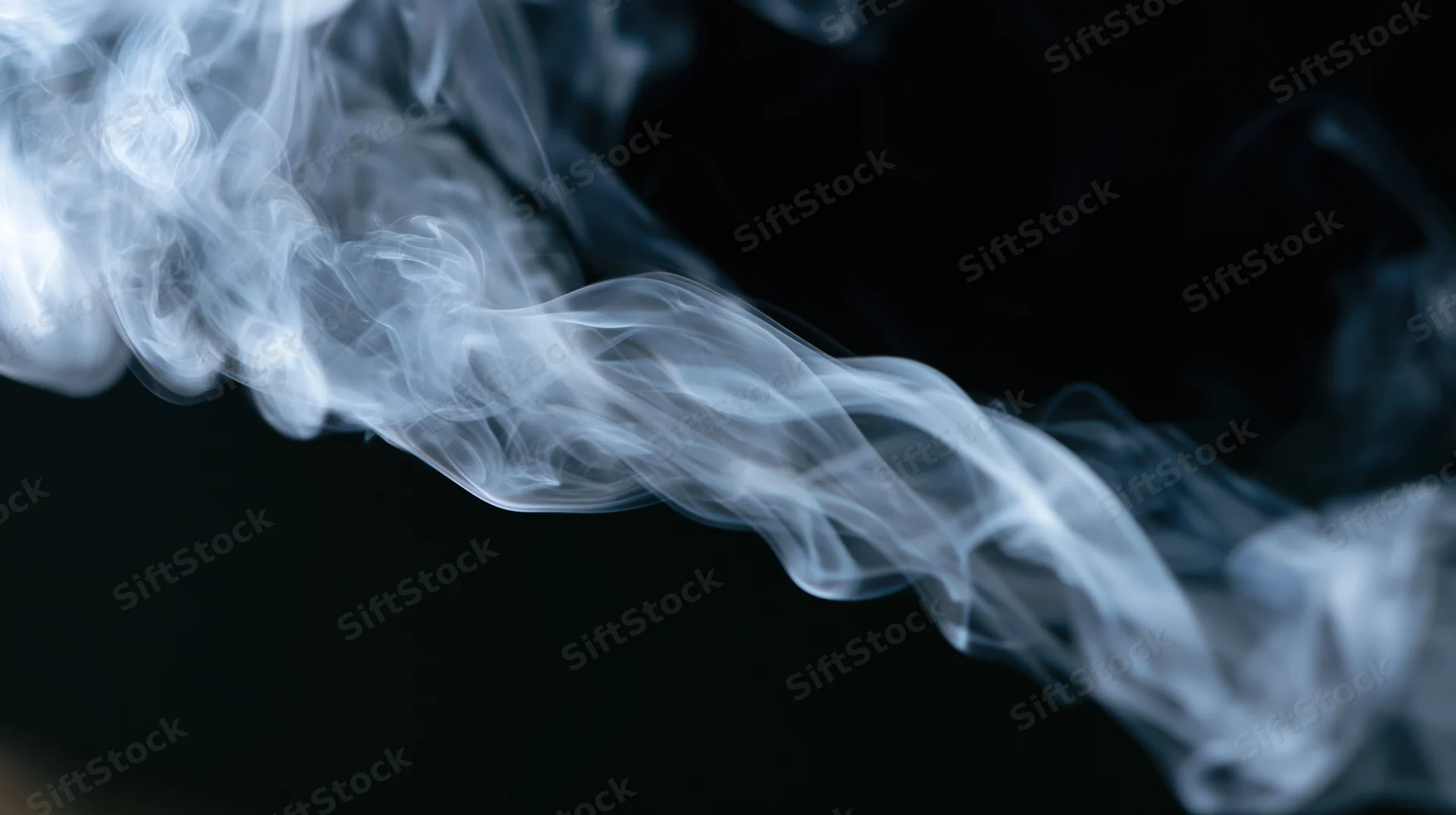 Swirling white smoke rising against a black background