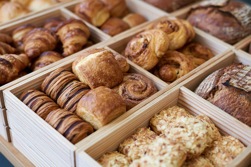 Assorted baked goods arranged in wooden boxes for display in a bakery