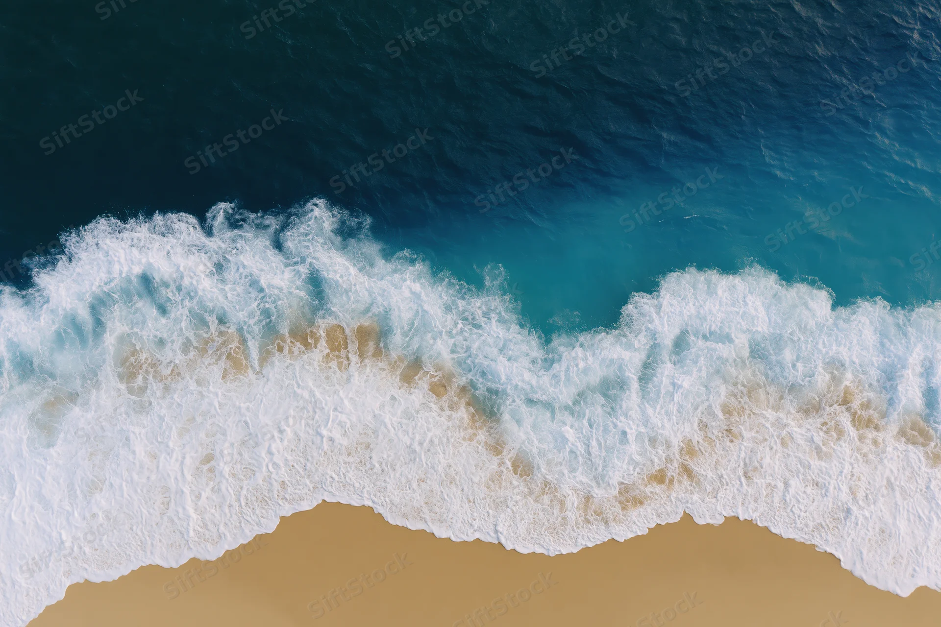 Aerial view of waves breaking on sandy beach