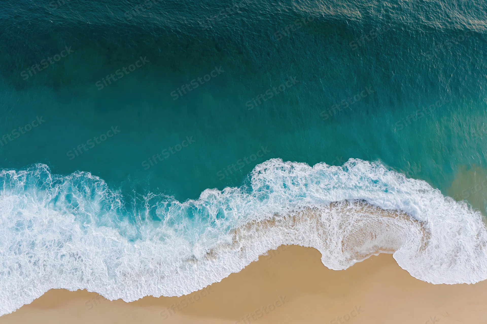 Aerial view of waves breaking on a sandy beach