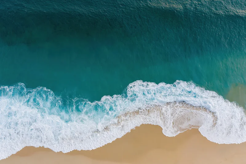 Aerial view of waves breaking on a sandy beach