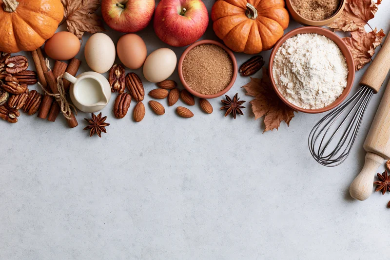 Autumn baking ingredients arranged on countertop with copyspace